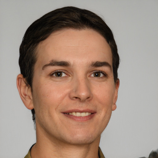 Joyful white young-adult male with short  brown hair and grey eyes