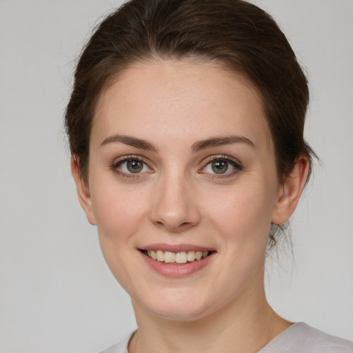 Joyful white young-adult female with medium  brown hair and green eyes