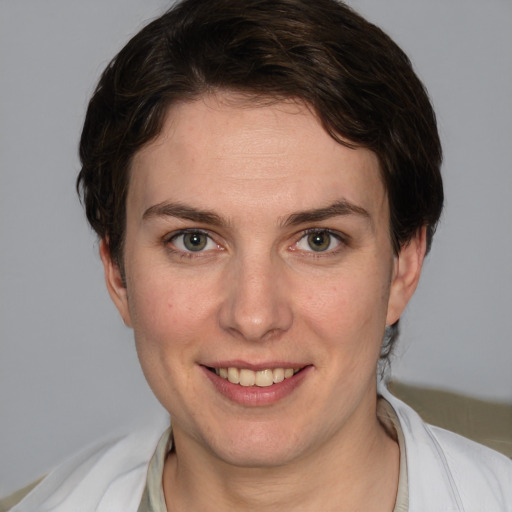 Joyful white young-adult female with short  brown hair and grey eyes