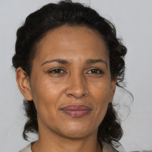 Joyful black adult female with medium  brown hair and brown eyes