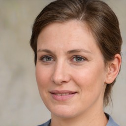 Joyful white adult female with medium  brown hair and grey eyes