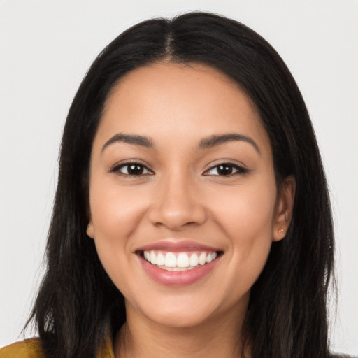 Joyful latino young-adult female with long  black hair and brown eyes