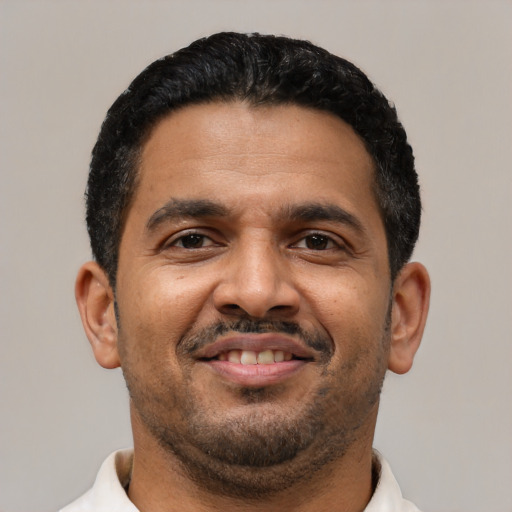 Joyful latino adult male with short  black hair and brown eyes