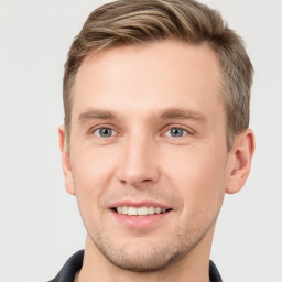 Joyful white young-adult male with short  brown hair and grey eyes