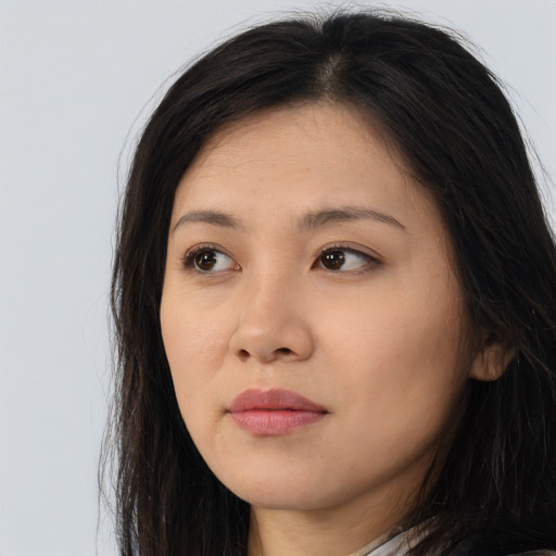 Joyful asian young-adult female with long  brown hair and brown eyes