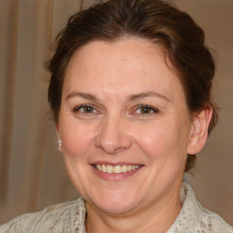 Joyful white adult female with medium  brown hair and blue eyes