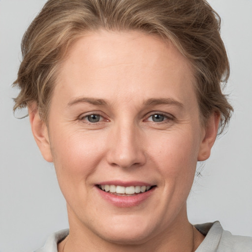 Joyful white young-adult female with short  brown hair and grey eyes