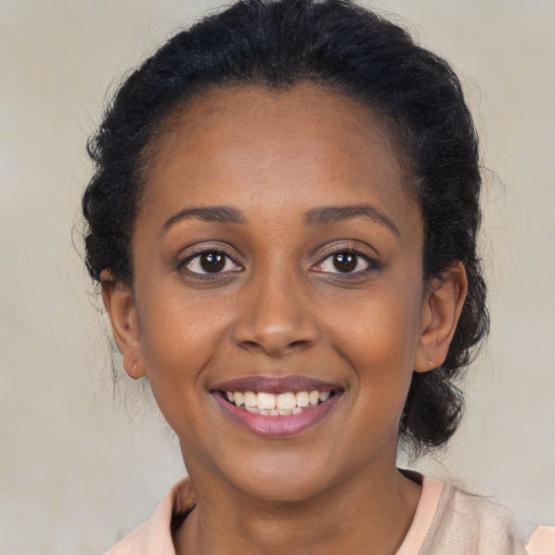 Joyful black young-adult female with long  brown hair and brown eyes