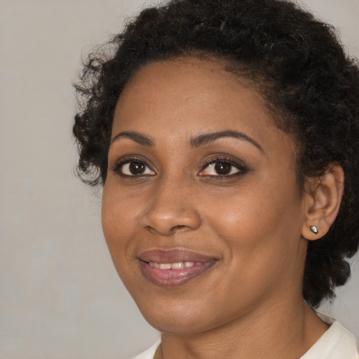 Joyful black young-adult female with medium  brown hair and brown eyes