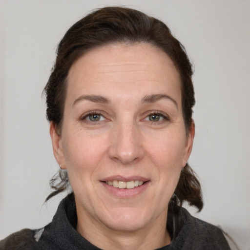 Joyful white adult female with medium  brown hair and grey eyes