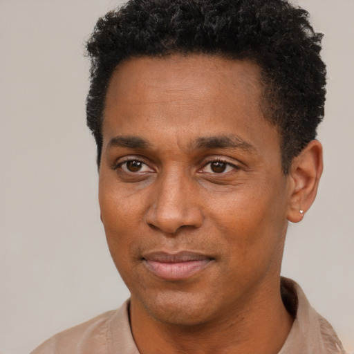 Joyful black young-adult male with short  black hair and brown eyes