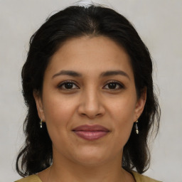 Joyful latino young-adult female with medium  brown hair and brown eyes