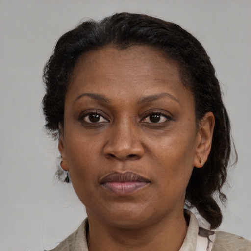 Joyful black adult female with short  brown hair and brown eyes