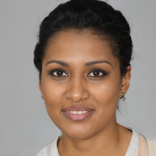 Joyful black young-adult female with short  black hair and brown eyes