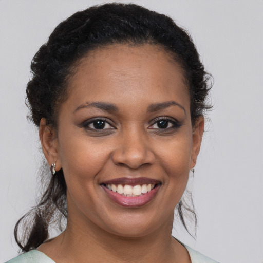 Joyful black young-adult female with medium  brown hair and brown eyes