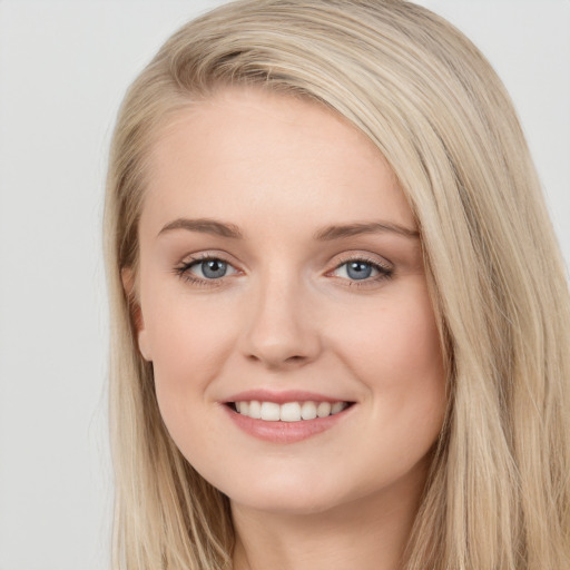 Joyful white young-adult female with long  brown hair and blue eyes