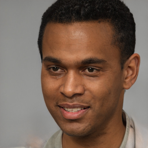 Joyful black young-adult male with short  black hair and brown eyes
