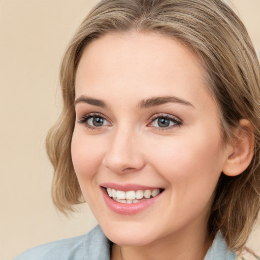 Joyful white young-adult female with medium  brown hair and blue eyes