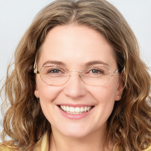 Joyful white adult female with long  brown hair and blue eyes