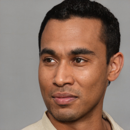 Joyful latino young-adult male with short  black hair and brown eyes