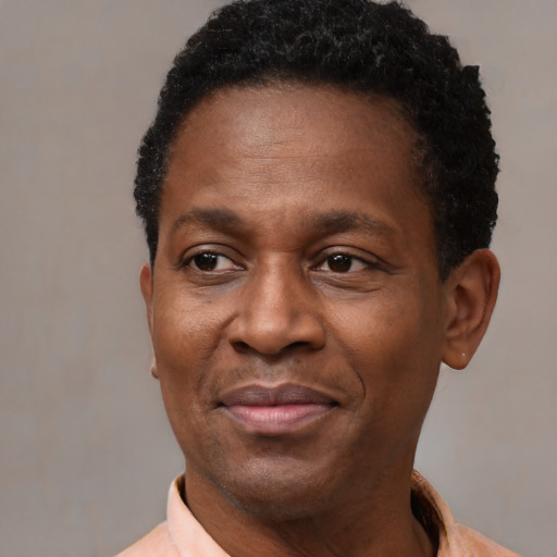 Joyful black adult male with short  black hair and brown eyes