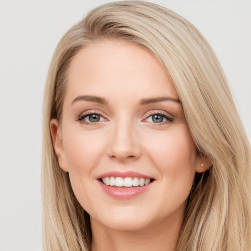 Joyful white young-adult female with long  brown hair and blue eyes