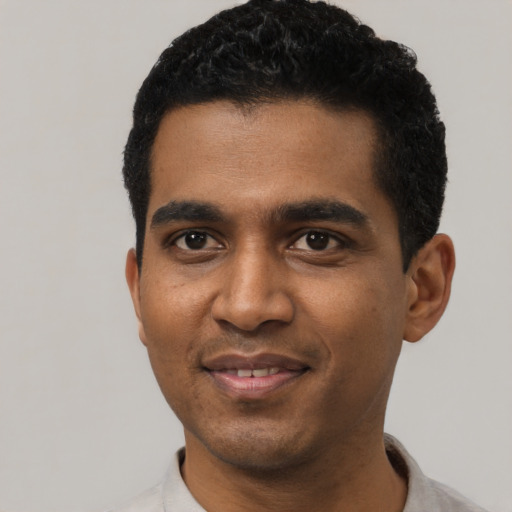 Joyful black young-adult male with short  black hair and brown eyes