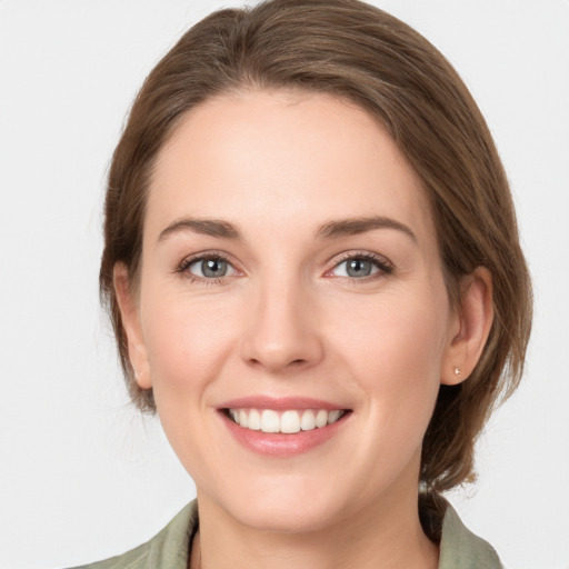 Joyful white young-adult female with medium  brown hair and grey eyes