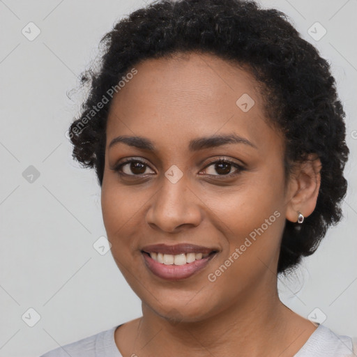 Joyful black young-adult female with short  black hair and brown eyes