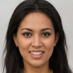 Joyful latino young-adult female with long  brown hair and brown eyes