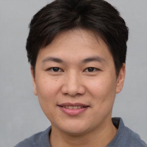 Joyful asian young-adult female with short  brown hair and brown eyes