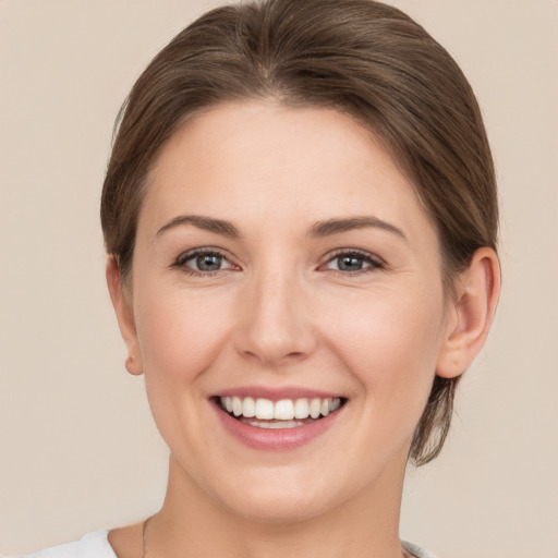 Joyful white young-adult female with medium  brown hair and grey eyes