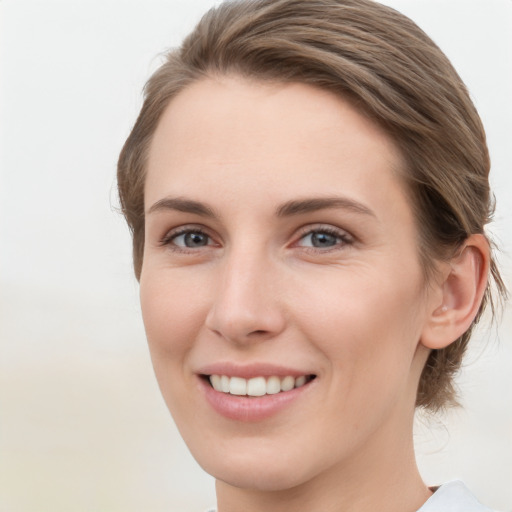 Joyful white young-adult female with medium  brown hair and grey eyes