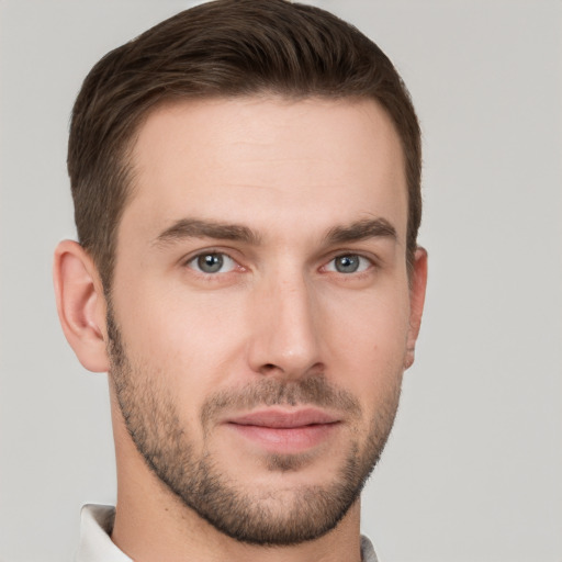 Joyful white young-adult male with short  brown hair and grey eyes