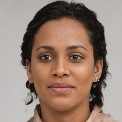 Joyful black young-adult female with medium  brown hair and brown eyes