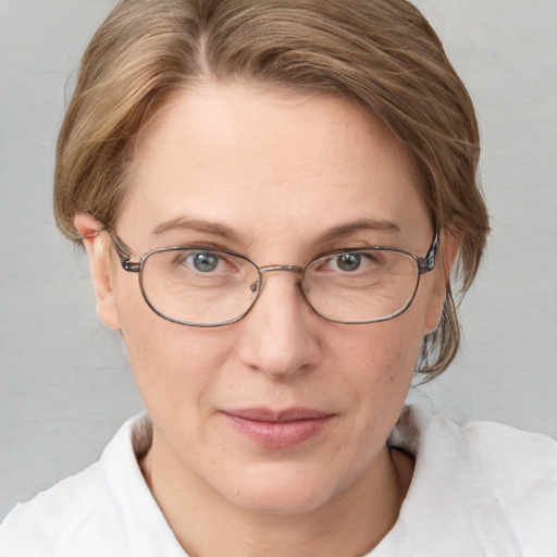 Joyful white adult female with medium  brown hair and blue eyes