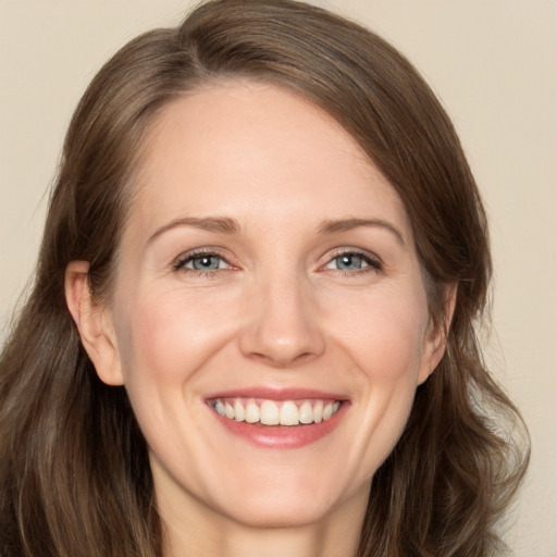 Joyful white adult female with medium  brown hair and grey eyes