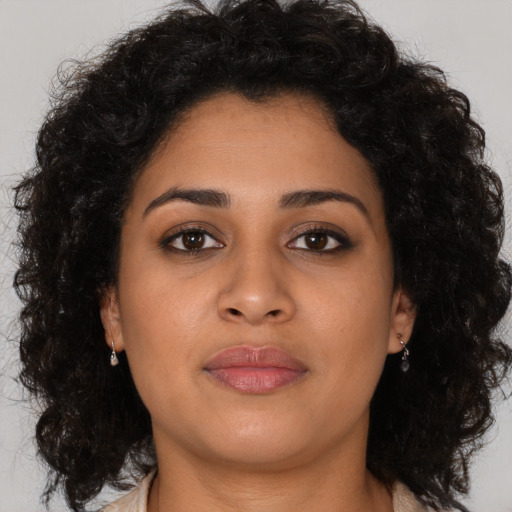 Joyful latino young-adult female with medium  brown hair and brown eyes