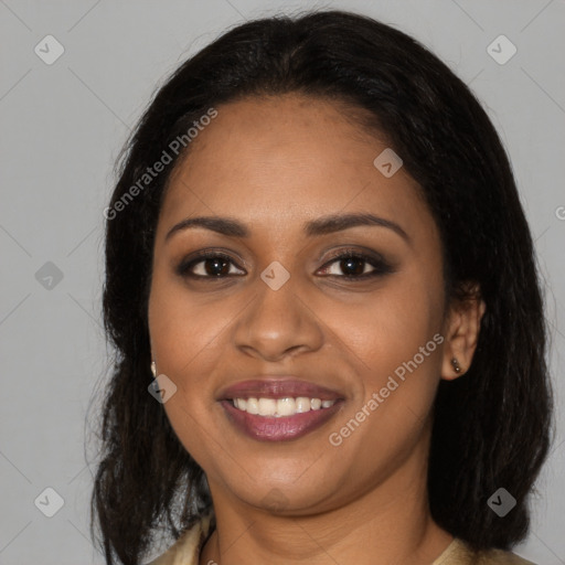 Joyful black young-adult female with long  black hair and brown eyes