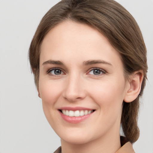 Joyful white young-adult female with medium  brown hair and grey eyes