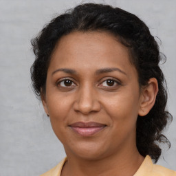 Joyful black adult female with medium  brown hair and brown eyes