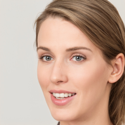 Joyful white young-adult female with long  brown hair and blue eyes