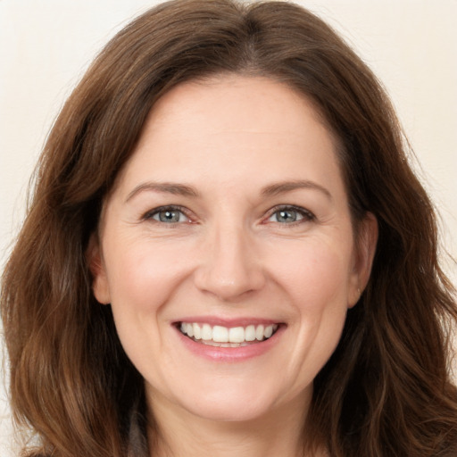 Joyful white young-adult female with long  brown hair and green eyes