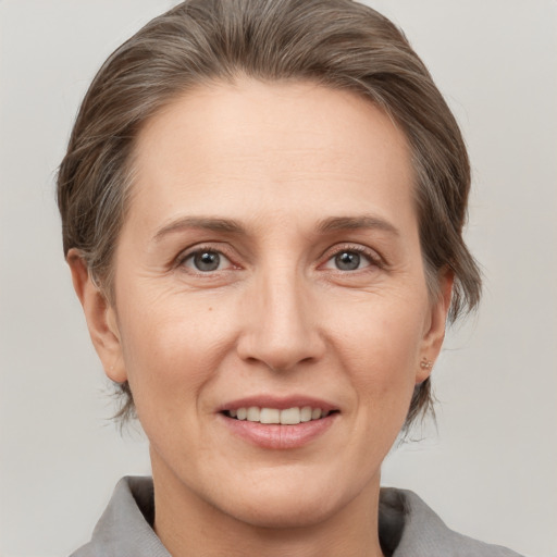 Joyful white adult female with medium  brown hair and grey eyes