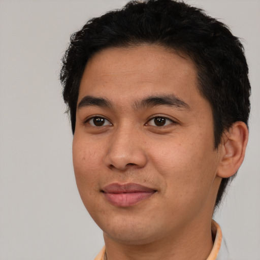 Joyful latino young-adult male with short  brown hair and brown eyes
