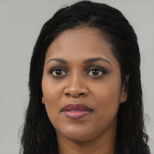 Joyful black young-adult female with long  black hair and brown eyes