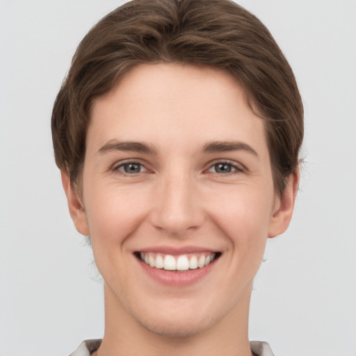 Joyful white young-adult female with short  brown hair and grey eyes