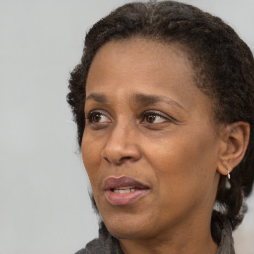 Joyful black adult female with short  brown hair and brown eyes