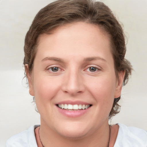 Joyful white young-adult female with medium  brown hair and blue eyes