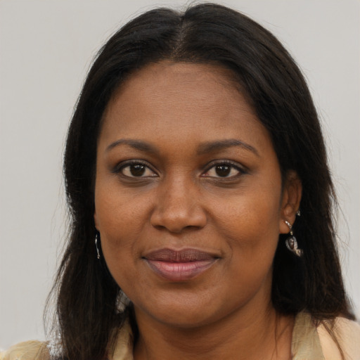 Joyful black adult female with long  brown hair and brown eyes